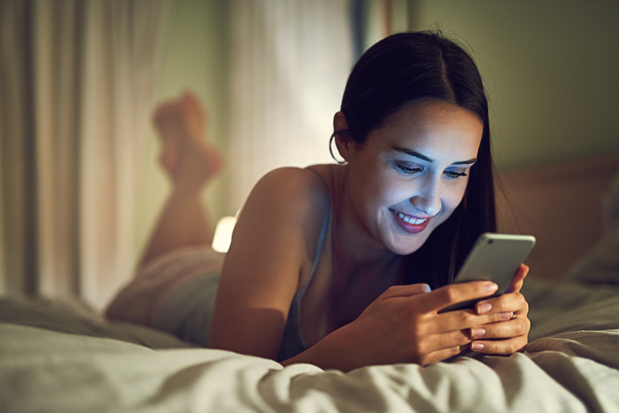 young woman reading good night messages send by a friend